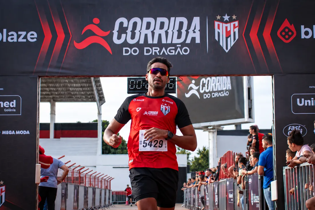 Corredor cruzando a linha de chegada sob o pórtico oficial